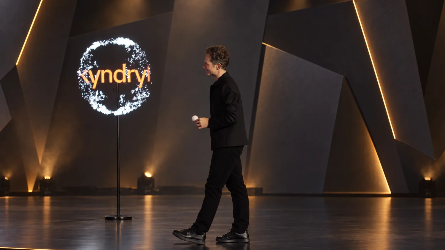 Sur la scène d&rsquo;une conférence, Romain Lalire traverse le plateau, micro à la main, devant l&rsquo;hélice montée sur son pied : un logo en lettres orange tourne à l&rsquo;intérieur du cercle.